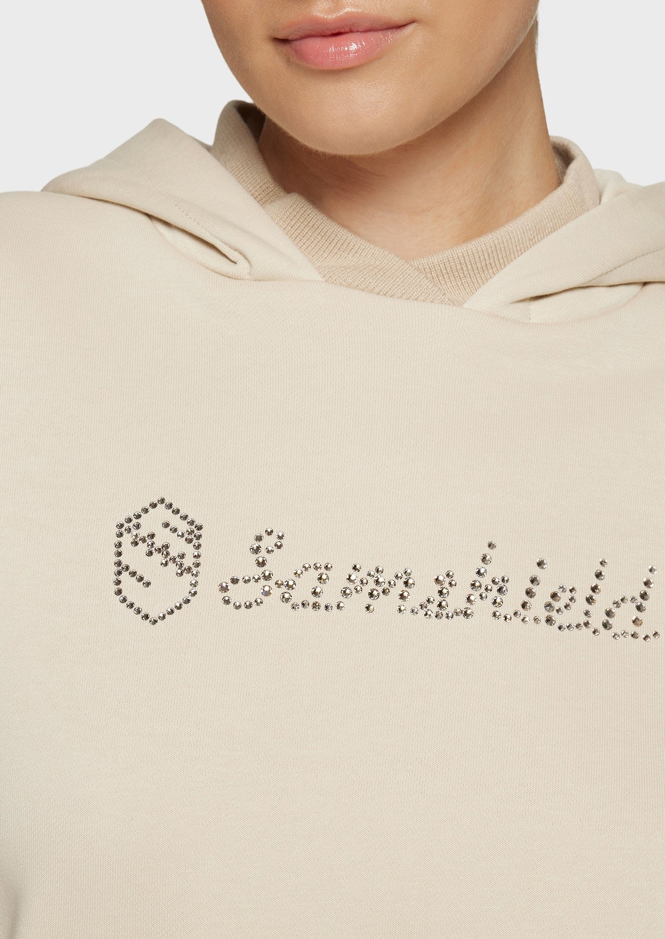 Woman wearing a beige sweatshirt on a beige background