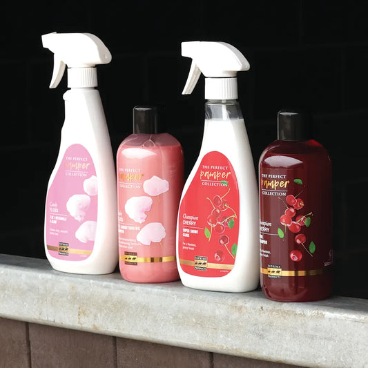 Four bottles of 'The Perfect Pamper' collection on a stone surface with a dark background