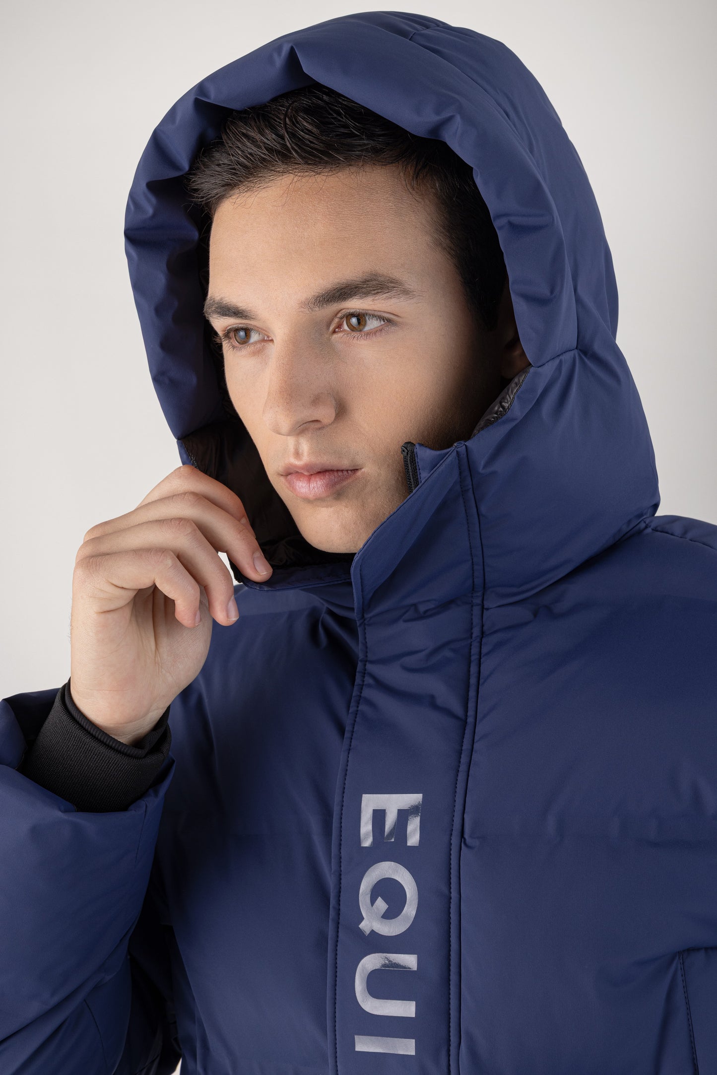 Person wearing a blue jacket with 'EQUILINE' branding on a white background