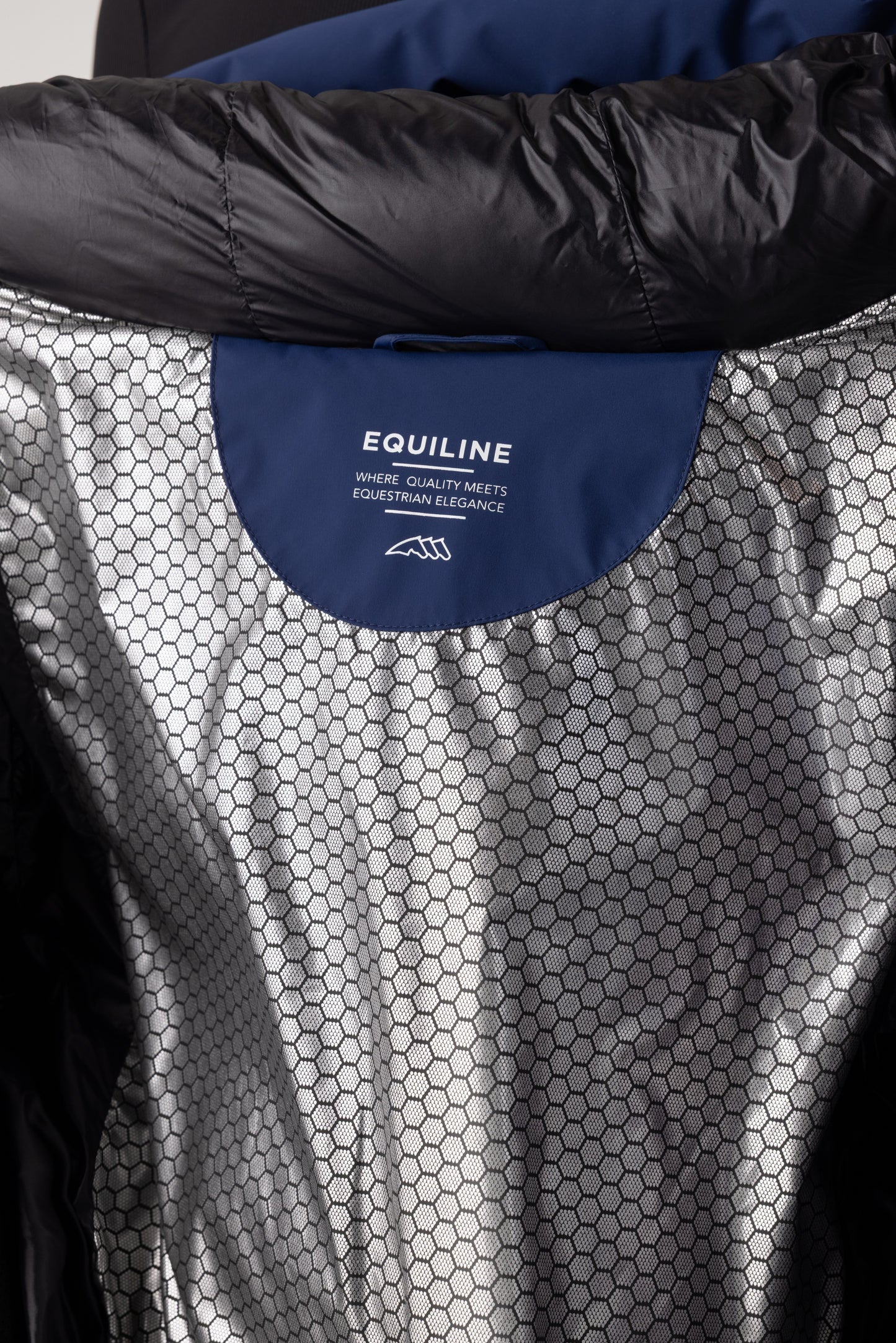 Close-up of a black and gray equestrian garment with Equiline logo.