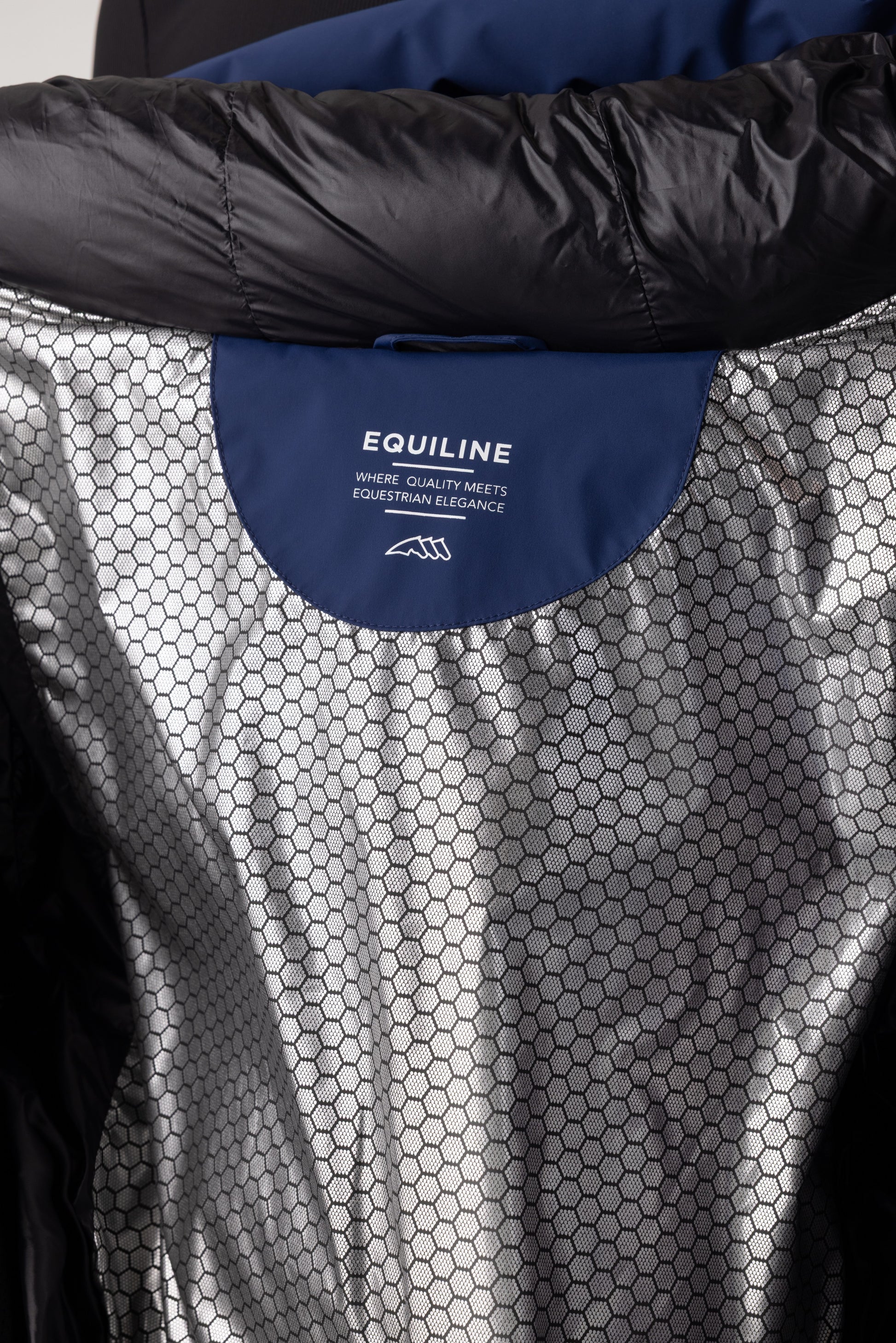 Close-up of a black and gray equestrian garment with Equiline logo.
