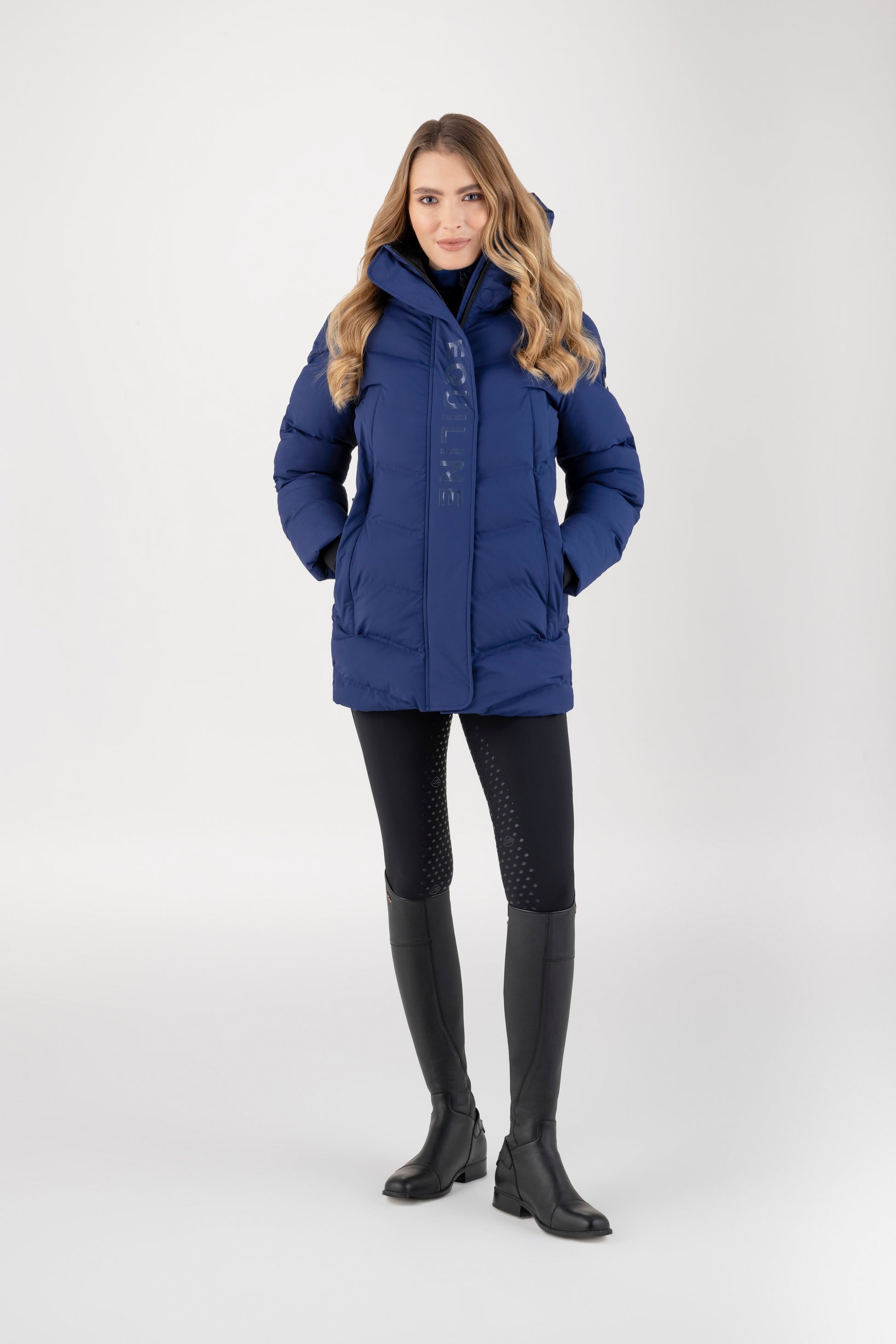 Woman wearing a blue winter coat on a white background