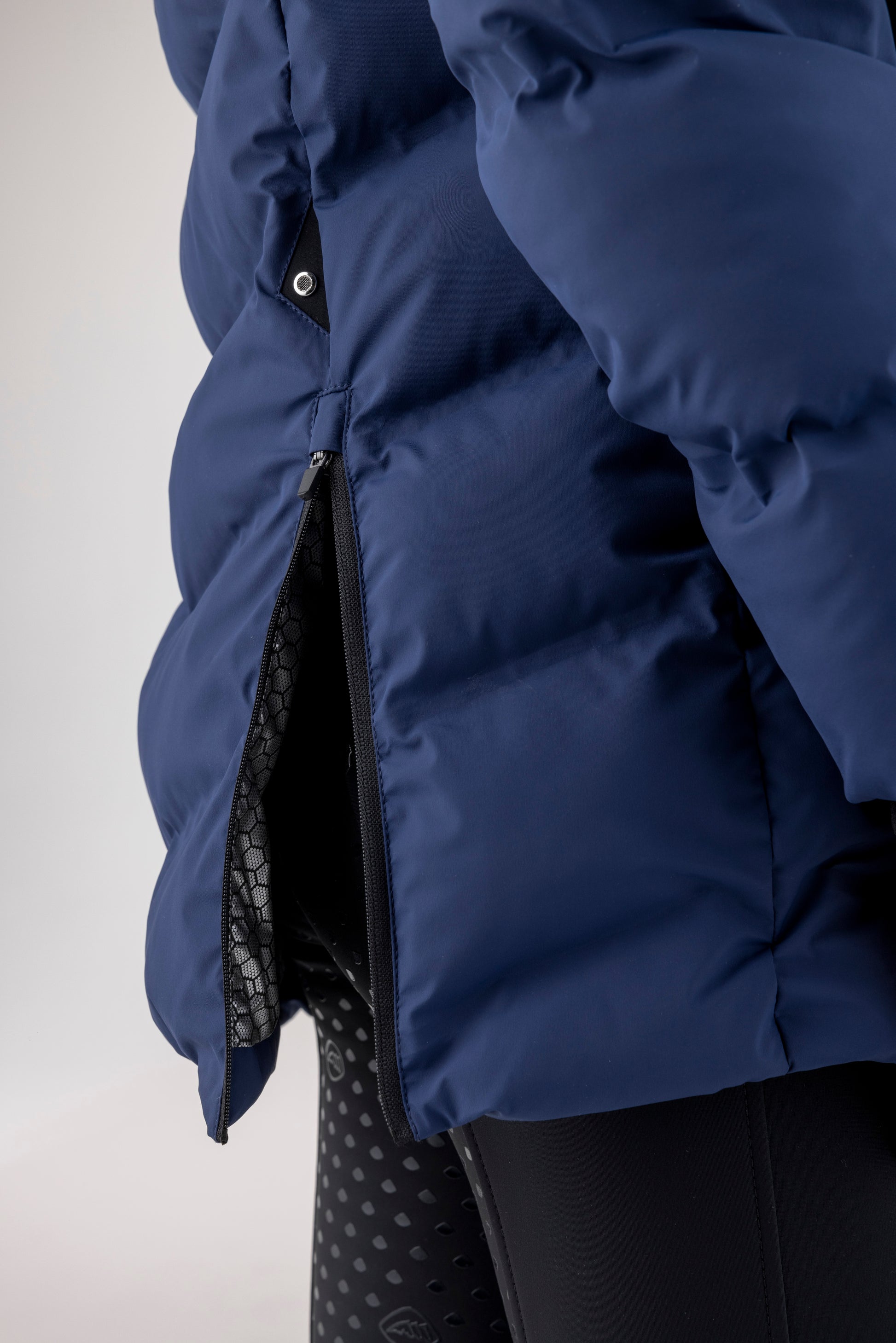 Close-up of a blue puffer jacket with a white background