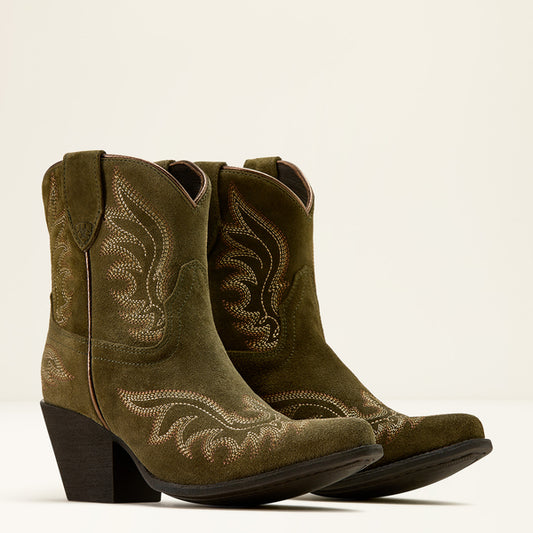 Pair of green cowboy boots with detailed stitching on a beige background