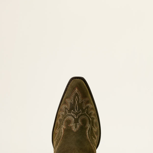 Close-up of a brown cowboy boot with intricate embroidery on a beige background