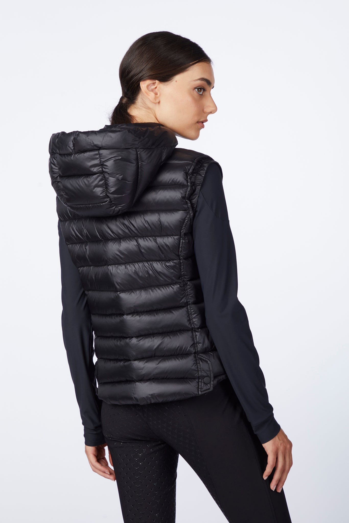 Woman wearing a black puffer vest on a white background