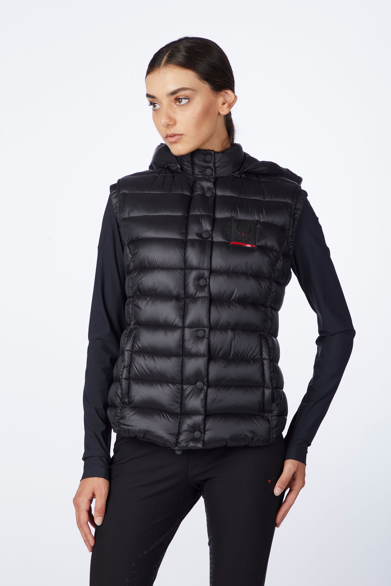 Woman wearing a black puffer vest on a white background