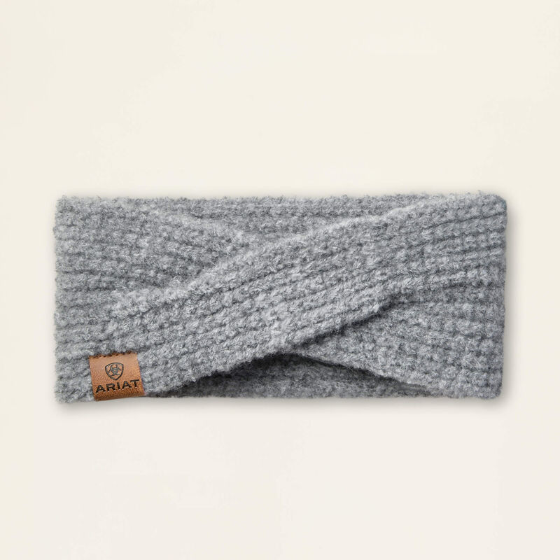 Gray knitted headband with a brand tag on a beige background
