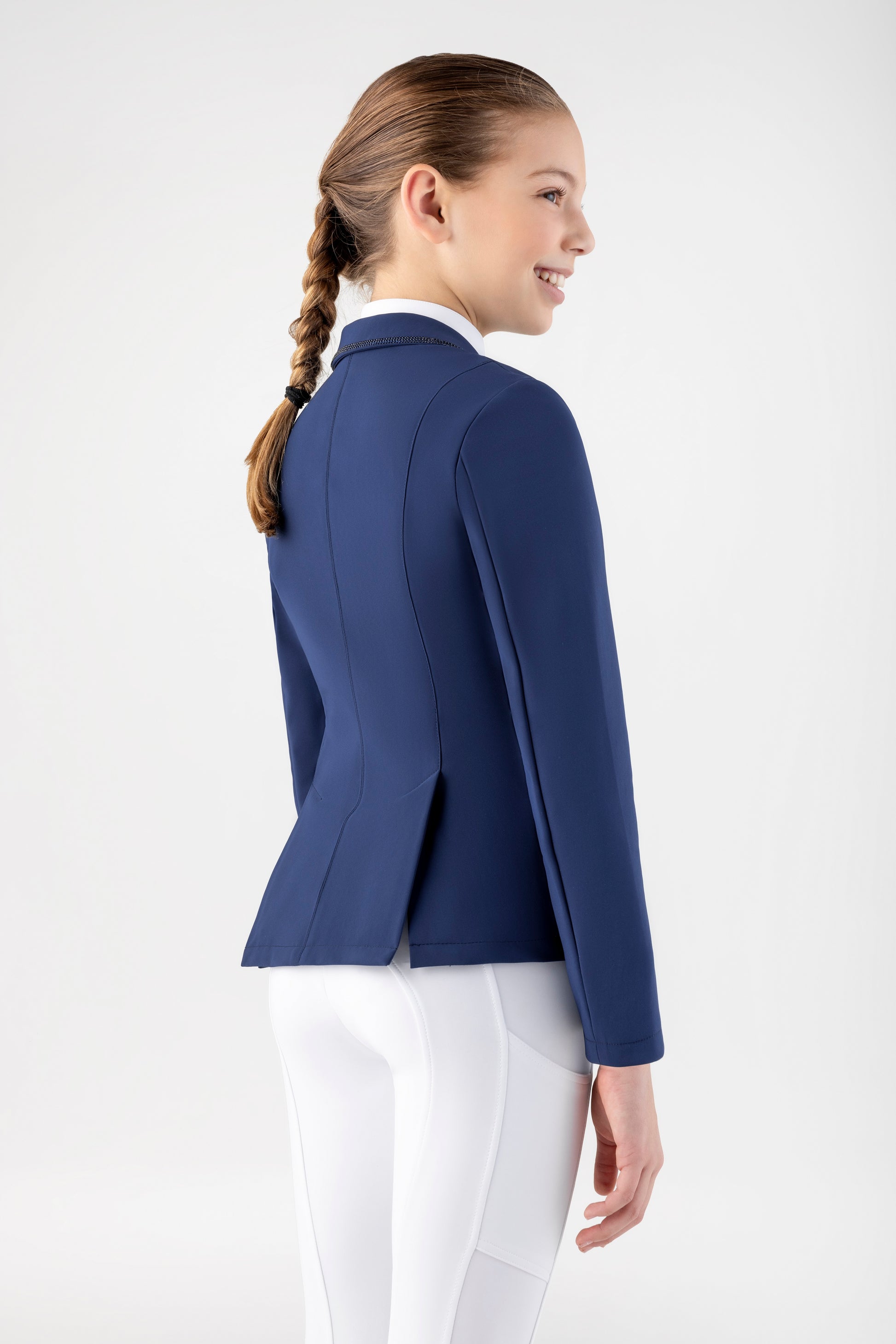 Person wearing a blue equestrian jacket and white pants on a white background