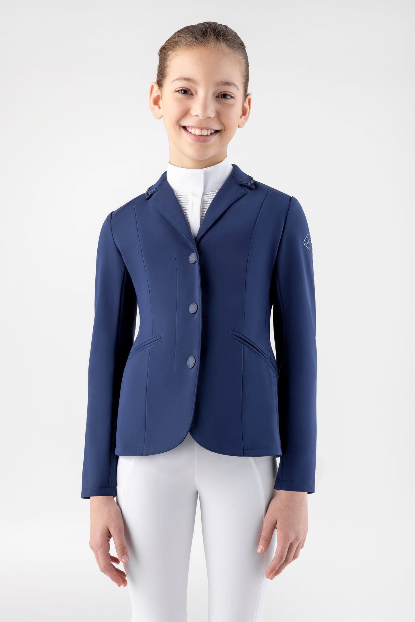 Girl wearing a navy blue equestrian jacket on a white background