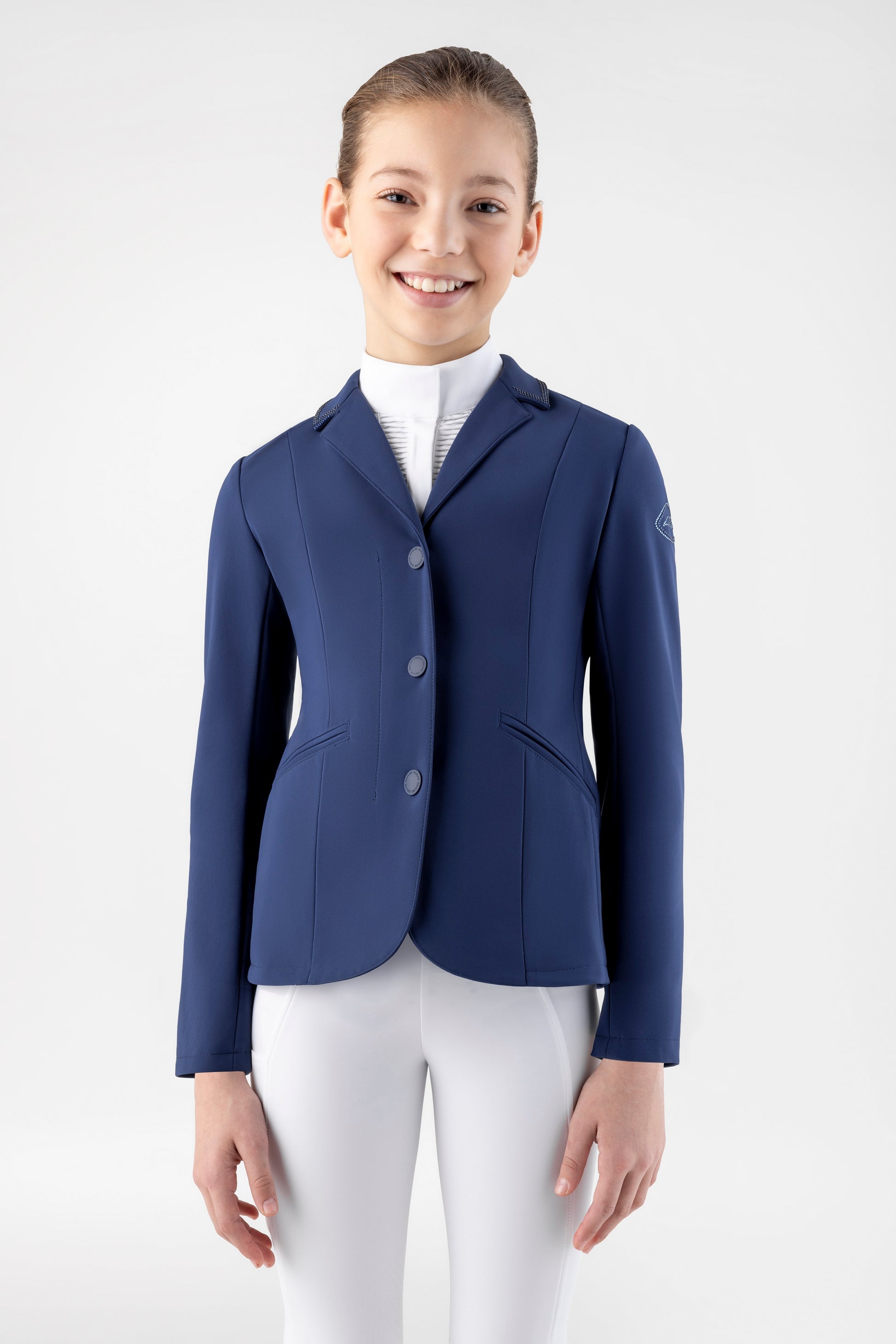 Girl wearing a navy blue equestrian jacket on a white background