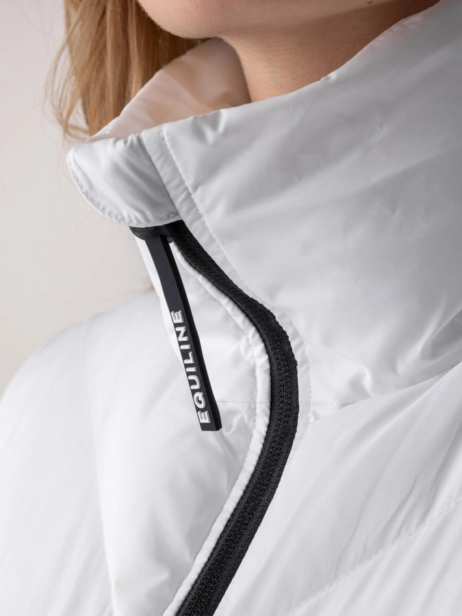 Close-up of a white garment with black trim featuring the brand 'Equiline'.