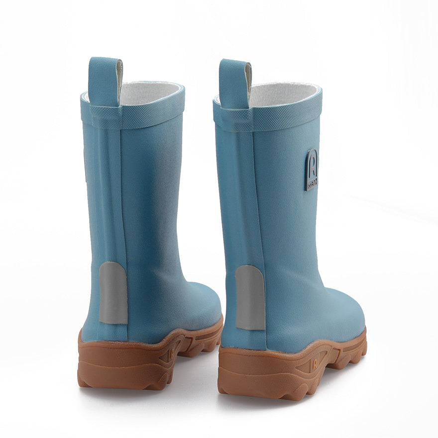 Pair of blue rubber boots with brown soles on a white background