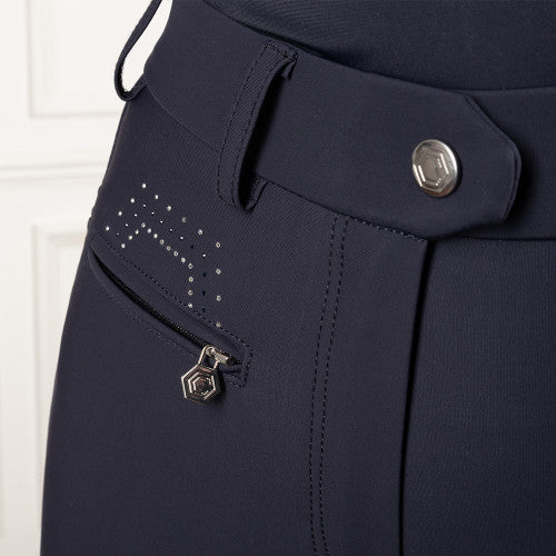 Close-up of navy blue tailored trousers showing the waistband, a zippered side pocket with silver studs, and a matching hexagonal zipper pull.