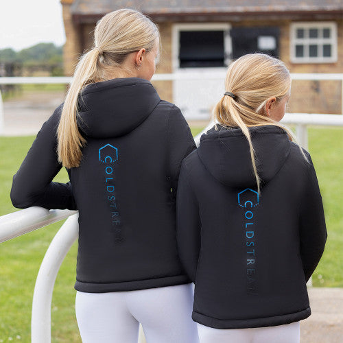 Two people wearing black hoodies with a visible brand logo, standing outdoors.