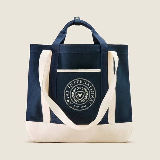 Navy tote bag with white handles and a logo on a beige background