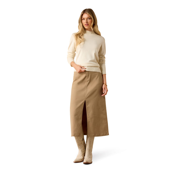 A woman modeling a cream-colored long-sleeve knit sweater with a ribbed mock neck, cuffs, and hem, paired with a beige skirt, against a solid white background.