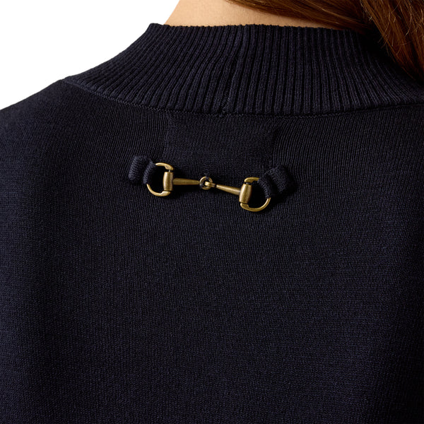 Close-up of the back of a dark navy knit sweater worn by a model, featuring a gold horsebit hardware detail at the center of the neckline.