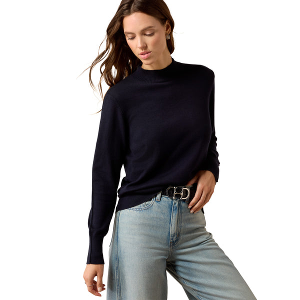 Woman wearing a blue turtleneck sweater and light blue jeans on a white background