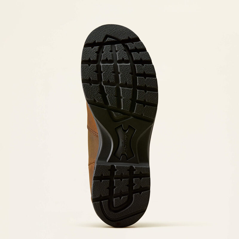 A close-up view of the black treaded outsole of a brown shoe, photographed against a plain off-white background.