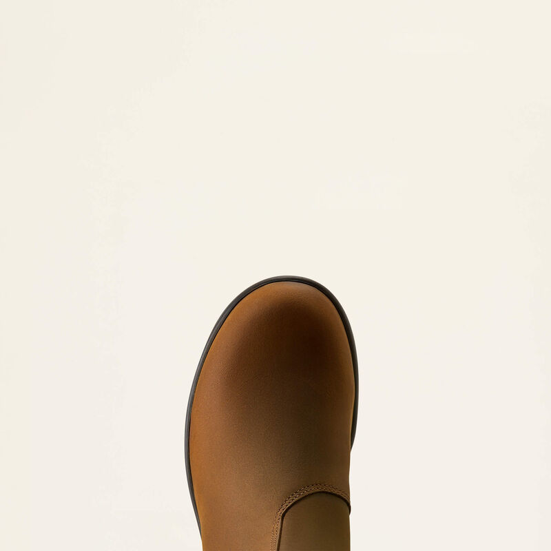 A close-up top-down view of a brown leather boot against a solid off-white background.