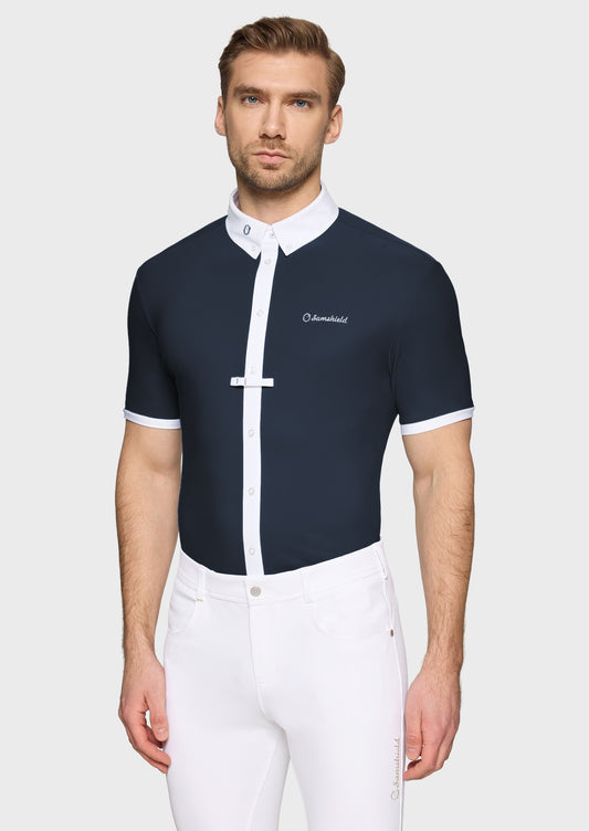 Man wearing a navy competition shirt and white breeches on a beige 