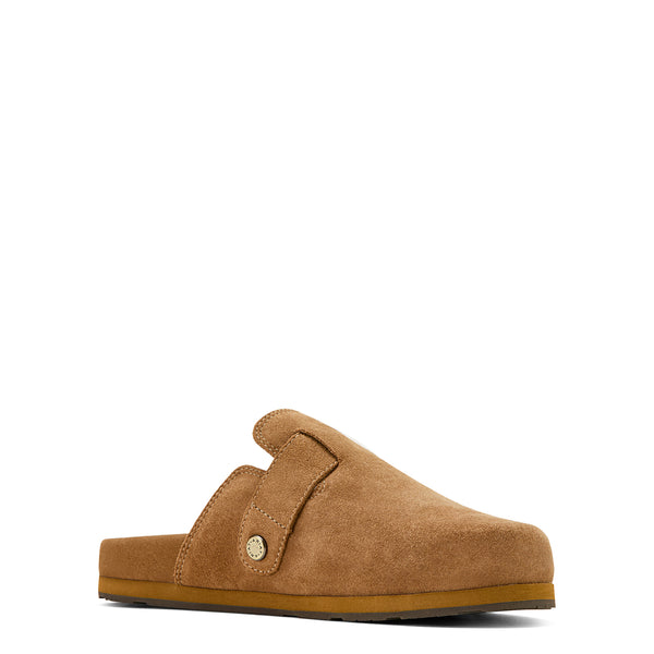 A single tan suede clog-style mule shoe with a strap and round metal button, shown from a side profile on a plain white background.