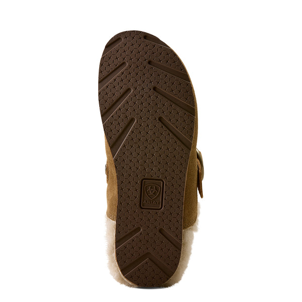 The outsole of a brown suede boot with a white shearling lining, showing a textured honeycomb pattern and a central brand logo.