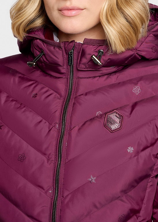 A close-up of a model wearing a deep plum purple hooded puffer jacket with a black front zipper and subtle embroidered star and flower patterns.