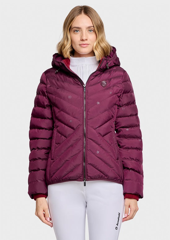 A woman modeling a quilted puffer jacket in deep burgundy with a small star pattern, shown against a plain light gray studio background.