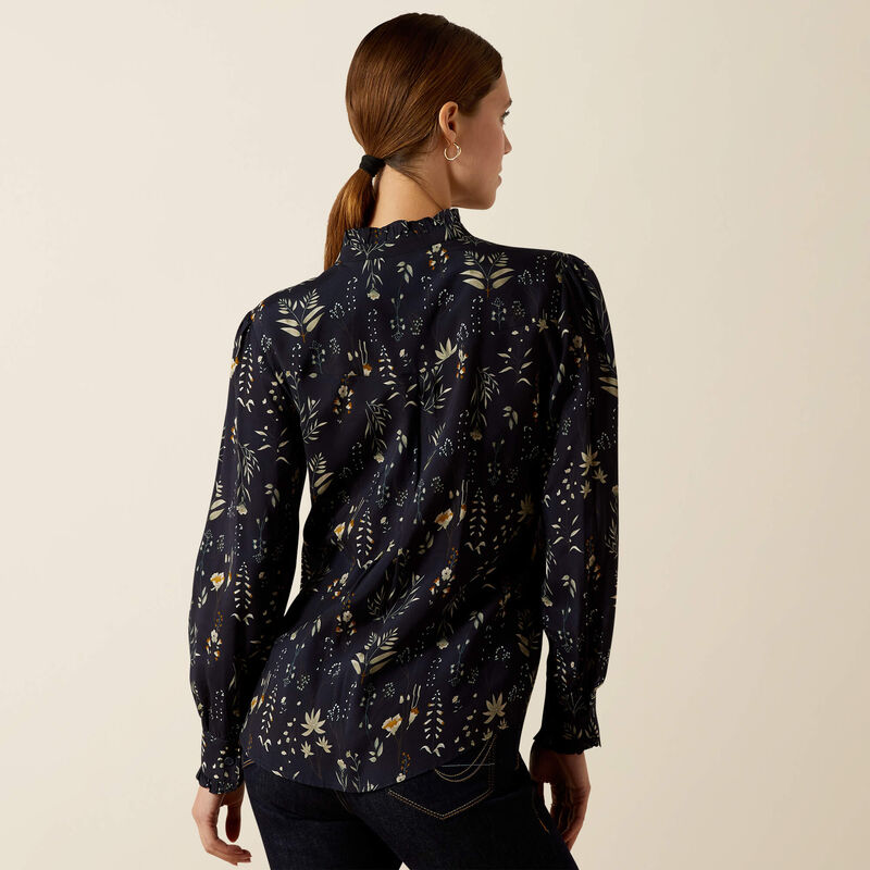 Woman wearing a dark floral patterned blouse against a beige background
