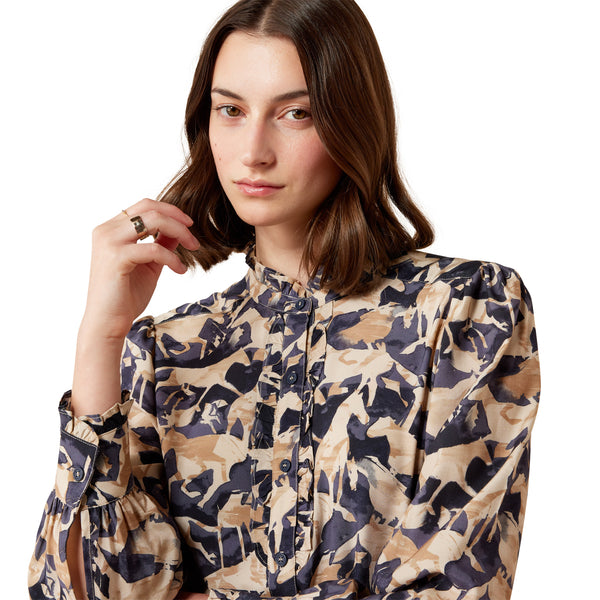 Model wearing a colourful blouse with a horse print on a white background