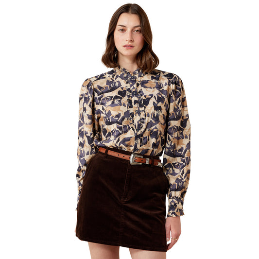 Model wearing a colourful blouse with a horse print and a brown skirt on a white background