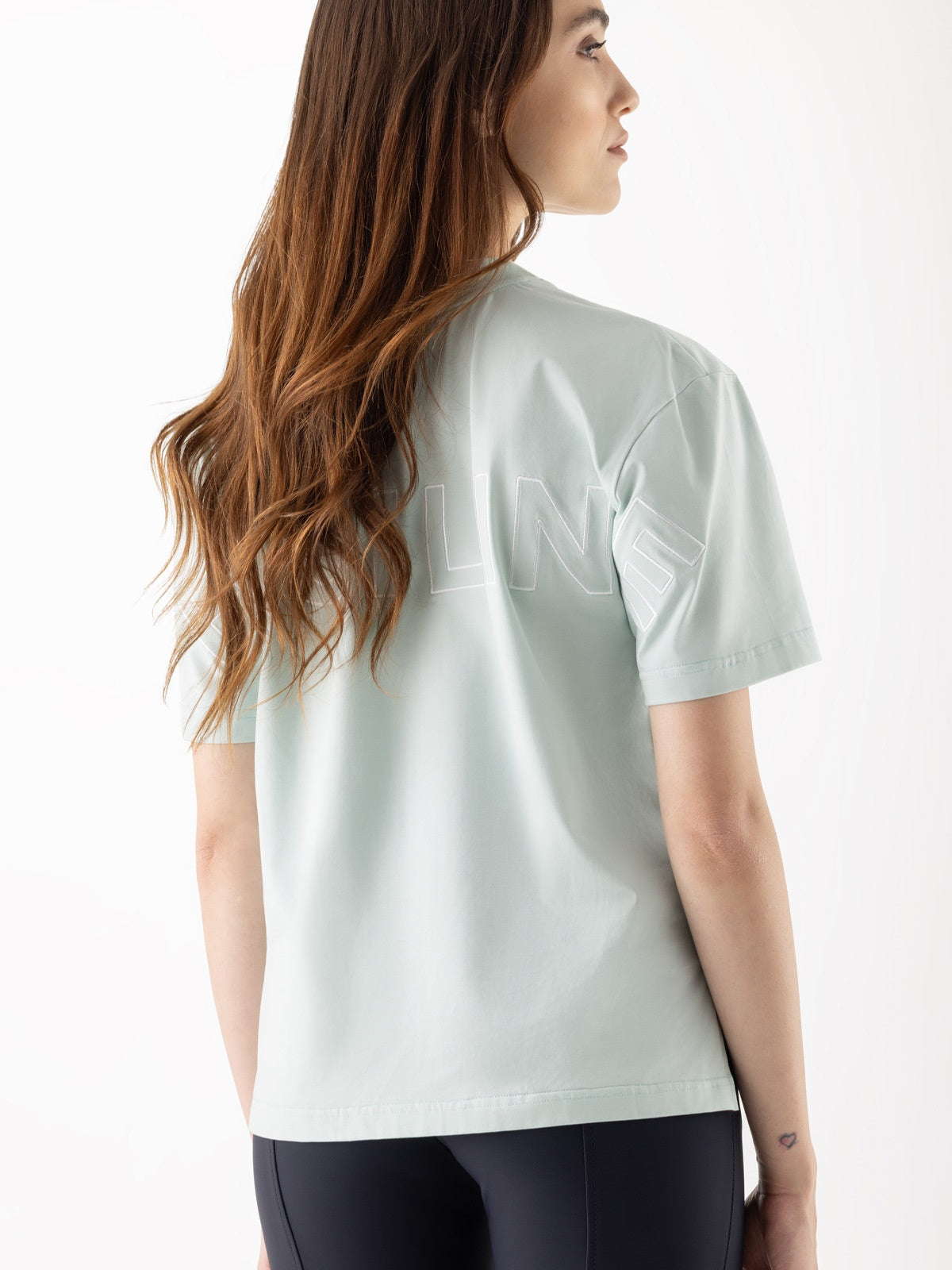 Woman wearing a light green t-shirt on a white background