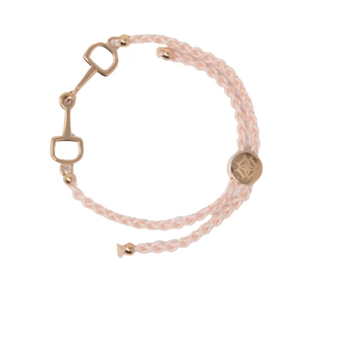Bracelet with pink braided design and gold horse bit on a white background