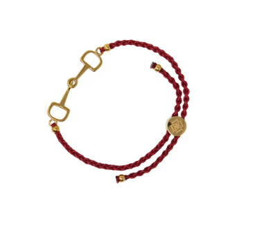 Bracelet with red cord and gold horse bit on a white background