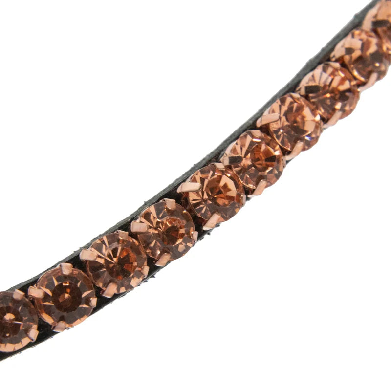 A close-up of a browband embellished with a diagonal row of faceted rose-gold-toned rhinestones on a plain white background.