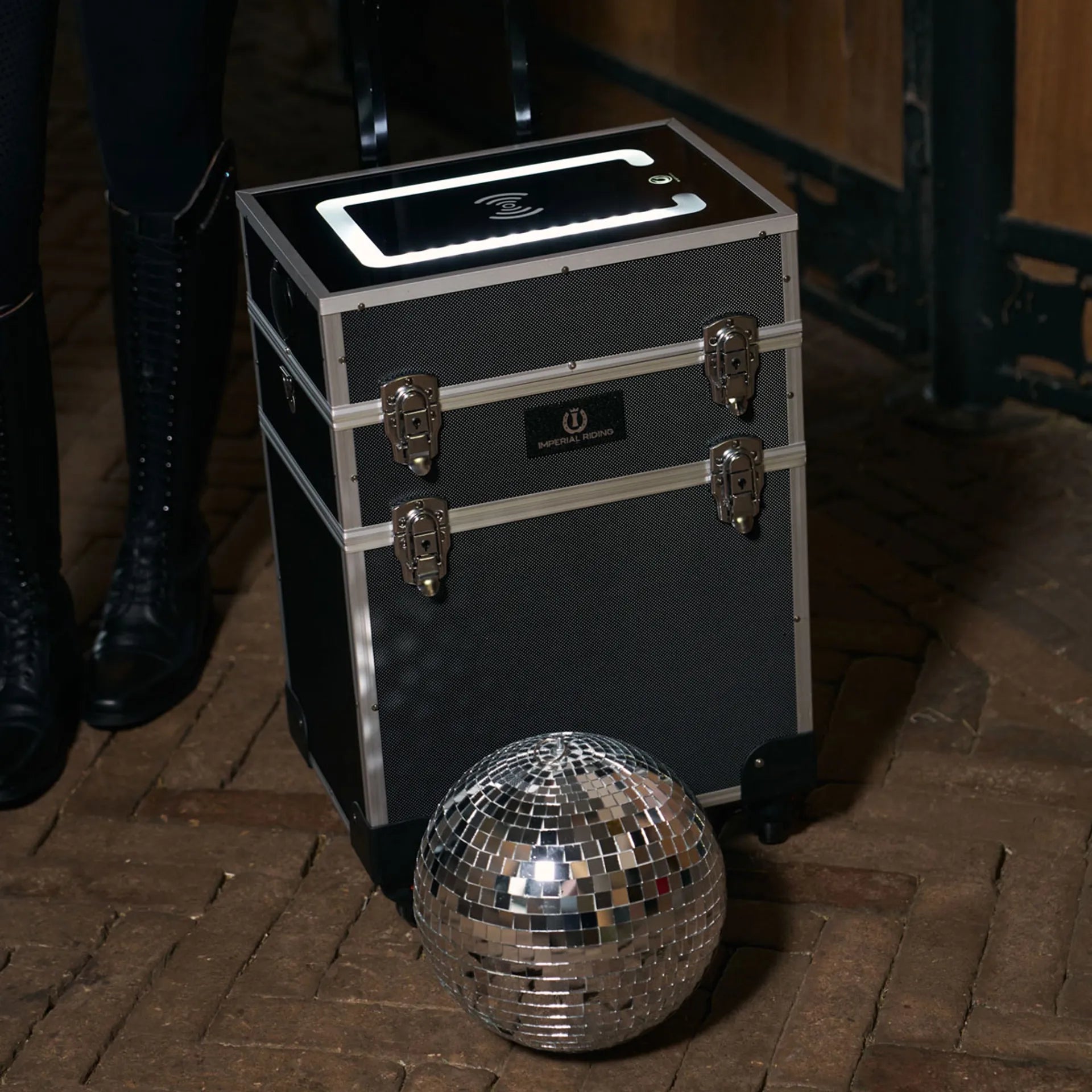 Black and silver grooming case with a disco ball on a wooden floor