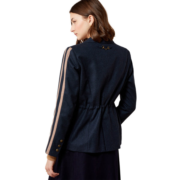 Woman wearing a navy blue blazer with beige accents on a white background