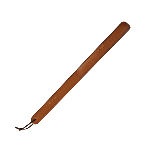 A long, slender brown wooden paddle with a dark brown leather loop and cord at one end, shown diagonally on a plain white background.