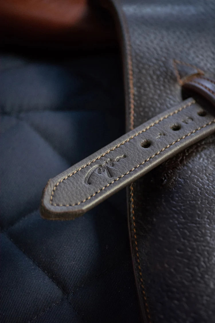 Close-up of a brown leather strap on a dark textured background.