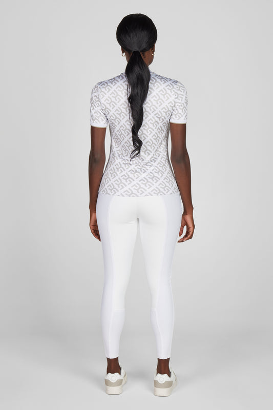 Person wearing a white lace top and white pants on a light gray background