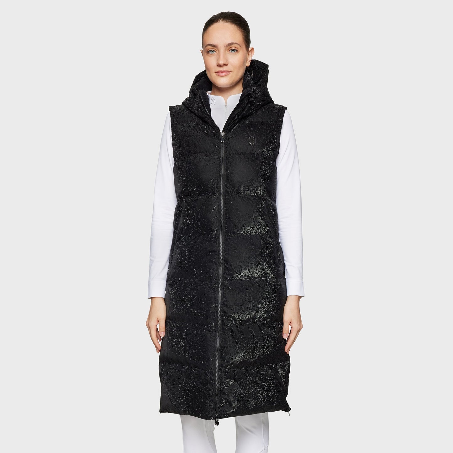 Woman wearing a long black puffer vest on a white background