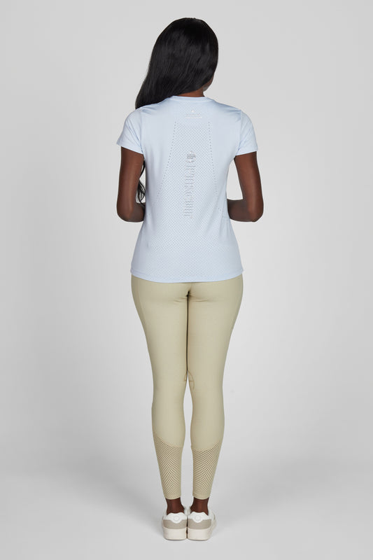 Model wearing a blue t shirt and a pair of beige breeches on a grey background