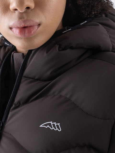 Close-up of a person wearing a dark brown puffer jacket with a white embroidered logo on the chest.