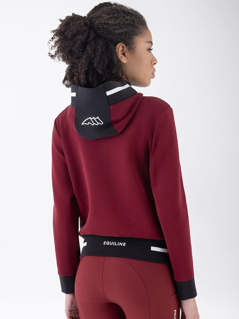 A woman shown from the back wearing a burgundy athletic hoodie with a black hood panel and white logo, paired with matching burgundy leggings with a black waistband.