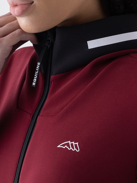 Close-up of a person wearing a dark red athletic jacket with a black collar, a white reflective stripe, and a white embroidered logo on the chest. The brand name 'EQUILINE' is visible on the zipper pull.