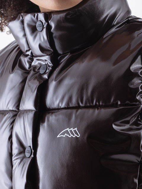 Close-up of a glossy black puffer jacket with a high padded collar, dark buttons, and a small white abstract chest logo.