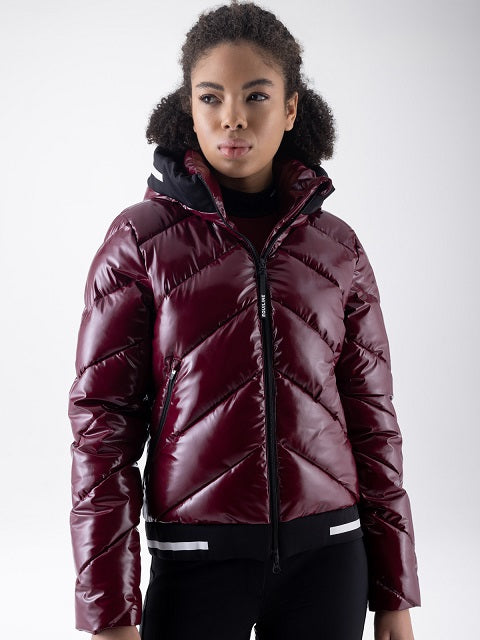 Woman wearing a glossy burgundy puffer jacket with a black collar featuring a reflective white stripe, worn by a model.