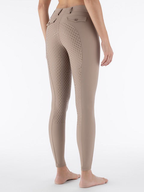 Rear three-quarter view of a model wearing beige equestrian riding tights with textured grip panels on the inner thighs and seat area, set against a plain white studio background.